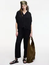 Blusa negra de manga corta con escote en V y detalle de bordado en la espalda.