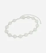 Cinturón de metal plateado, estilo cadena, compuesto por discos circulares con diseño de espiral concéntrica. Se ajusta mediante una cadena extensible con cierre de mosquetón.