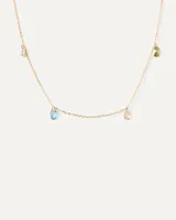 Collar dorado con cadena fina y colgantes de circonitas multicolores en forma de gota.