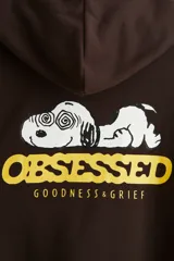 Canguro marrón de peso medio, con capucha de doble capa con cordón de ajuste, bolsillo canguro frontal y estampa con la palabra "OBSESSED" en amarillo en el pecho. Presenta puños y bajo acanalados.
