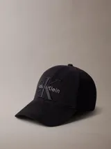 Gorra de béisbol Calvin Klein de color negro, con visera curva y cierre ajustable en la parte trasera. Presenta el logo de la marca bordado en el frente con un diseño de monograma a capas.