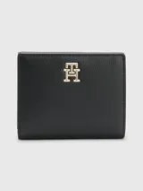 Billetera mediana Tommy Hilfiger plegable de color negro con acabado granulado. Tiene cierre de botón a presión, múltiples ranuras interiores para tarjetas e insignia del monograma TH en la parte delantera.