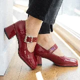 Zapato estilo Mary Jane de cuero vacuno con acabado brillante, punta cuadrada y taco bloque. Cuenta con una tira ajustable sobre el empeine con hebilla metálica.