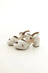 Sandalias de taco alto ancho con plataforma, color plateado metalizado, con tiras cruzadas en el empeine y tira al tobillo con hebilla ajustable.