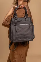 Cartera mochila de diseño versátil, color rosado, confeccionada en material sintético impermeable. Cuenta con doble asa superior, correas ajustables para usar como mochila, compartimento principal con cierre y bolsillo frontal con cierre decorado con tirador largo.