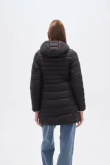 Campera larga acolchada color negro, con cierre frontal y cuello alto. Presenta costuras horizontales que crean un efecto puffer.