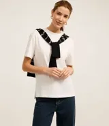 Blusa de manga corta confeccionada en algodón pima, con cuello redondo y diseño liso. Presenta un corte clásico con el bajo ligeramente más largo en la parte posterior.