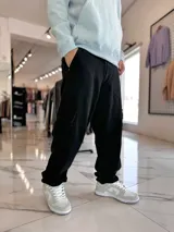 Pantalón cargo de jean azul claro, con bolsillos laterales tipo cargo en las piernas y bolsillos frontales aplicados, de corte ancho y holgado.