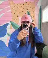 Gorro de béisbol rosa con la letra K bordada en rojo en el frente.