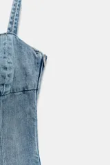 Vestido mini de denim con escote corazón, tirantes finos ajustables y falda acampanada con volante en el bajo.