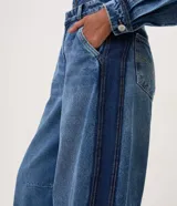 Pantalón de jean estilo barrel con tiro alto, recortes laterales sastreros y diseño amplio en las piernas. Confeccionado en algodón con lavado medio.