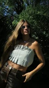 Top strapless de cuero color gris claro, con diseño de tablitas verticales en el frente y calce al cuerpo.