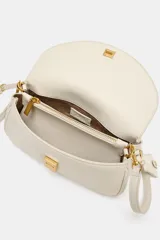 Bolso bandolera alargado de color blanco marfil con solapa redondeada y detalle metálico dorado. Incluye doble asa bandolera ajustable, una de ellas en tejido.