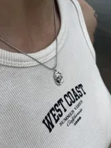 Collar plateado con cadena fina y dije ovalado con relieve de una rosa.