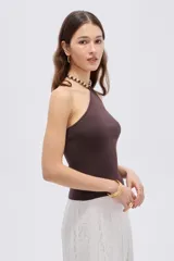 Top de viscosa color marrón, con diseño al cuerpo, escote halter y detalle de cuentas en el cuello.