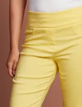 Pantalón capri blanco de gabardina elastizada. Pretina ancha elastizada, delantera con bolsillos simulados y trasera con bolsillos aplicados.