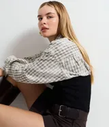 Short pollera de estilo sastre con diseño de plegado delantero, cintura estructurada y cinturón lateral integrado con hebilla metálica.