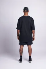 Short de baño negro liso con cintura elástica, bolsillos laterales y trasero con velcro, suspensor interno y etiqueta en el frente.
