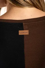 Sweater de algodón con diseño bicolor en bloques, combinando tonos marrón y negro. Presenta cuello redondo, mangas largas y una textura acanalada.