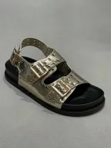 Sandalia plateada con plataforma negra, tiras anchas con hebillas y detalles de perforaciones.