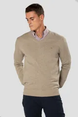 Suéter de tejido fino color azul marino, con cuello en V y manga larga. Presenta un pequeño logo bordado en el pecho.