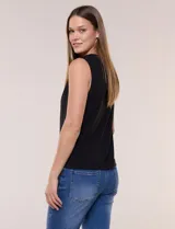 Blusa blanca de seda fría, sin mangas, con escote redondo, frunces sutiles y pequeñas aberturas verticales sujetas por cuentas metálicas doradas.