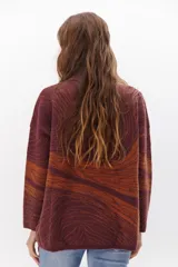 Buzo de punto azul con diseño abstracto en tonos beige.