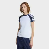 Remera Adidas de ajuste ceñido, color celeste claro con mangas cortas en azul marino y las icónicas tres rayas blancas en los hombros. Presenta cuello redondo acanalado y el logo del trébol bordado en el pecho.