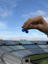 Par de dijes colgantes con forma de sol, realizados en acrílico color azul vibrante, diseñados para ser utilizados en aros tipo argolla.
