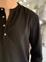 Camisola blanca de lino de manga larga con cuello mao y tira de botones frontal.