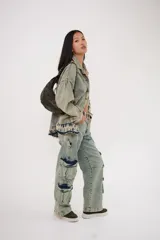 Cartera negra de cuero con forma de medialuna y tachas en zigzag.