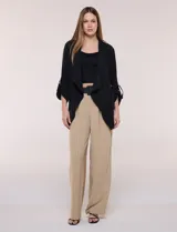 Chaqueta liviana color beige de silueta fluida y diseño abierto, con solapa caída, cintura con cordón ajustable y mangas 3/4 con presilla y argolla metálica.