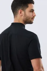 Camisa de lino y algodón de manga corta, color negro, con cuello mao, cierre frontal con botones y bolsillo ojal en el pecho.