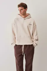 Hoodie de felpa color beige, con capucha, bolsillo frontal tipo canguro y pequeño logo de la marca estampado en el pecho.