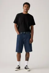 Bermuda de jean azul oscuro, corte holgado y largo hasta la rodilla.