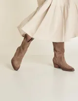 Botas de caña media color marrón de cuero descarne, con puntera fina y taco bajo de madera.