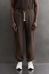 Pantalón jogger relaxed fit de Zara Athleticz confeccionado en tejido de algodón color marrón, con cintura elástica ajustable mediante cordón en contraste, bolsillos laterales y bajo con puño elástico.