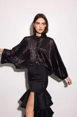 Camisa oversize de seda metalizada con diseño estampado de efecto terciopelo, hombros caídos, mangas murciélago amplias y cierre frontal con botones.
