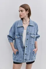 Campera de jean de silueta amplia, con cuello clásico y cierre frontal con botones. Diseño con bolsillos con solapa en el frente y bolsillos laterales, hombros caídos y terminaciones pespunteadas.