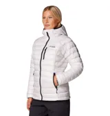 Campera técnica Columbia Titanium, modelo Arctic Crest, de diseño acolchado con tecnología Omni-Heat Arctic. Cuenta con capucha integrada, cierre frontal completo, bolsillo en el pecho y bolsillos laterales con cremallera, todos en color negro contrastante sobre la base blanca.