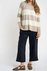 Sweater de punto con diseño de rayas horizontales anchas en color bordó y beige. Presenta cuello redondo con detalle de lurex, mangas largas y puños y ruedo acanalados.