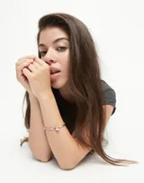 Pulsera semirígida plateada con detalle de cuero rosa y esfera plateada.