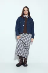 Campera de jean color negro con cuello de pana en tono marrón, cierre frontal con botones y bolsillos en el pecho. Presenta un diseño de corte relajado y ligeramente cropped, con interior forrado en corderito para mayor abrigo.