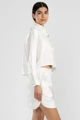 Short blanco de lino italiano con hilo metalizado, corte relajado y talle medio.