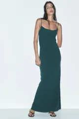Vestido largo verde esmeralda de tirantes finos ajustables y escote fluido drapeado. Tiene forro interior y cierre trasero con gancho metálico.