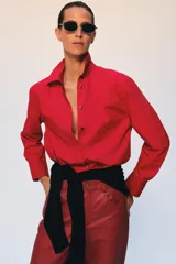 Camisa oversize verde de popelina de algodón, con cuello solapa, manga larga y cierre frontal con botones ocultos bajo solapa.