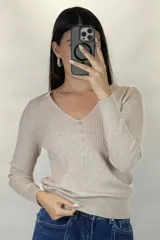Buzo de hilo gris con textura acanalada, escote en V y cierre frontal con botones pequeños.