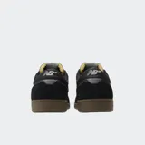 Championes urbanos New Balance modelo 508, color negro con detalles en gris y blanco, confeccionados en gamuza y malla, con logo "N" característico en los laterales y entresuela marrón.