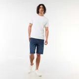 Bermuda vaquera slim fit de corte clásico y color azul, con diseño de cinco bolsillos y cierre frontal con botón y cremallera.