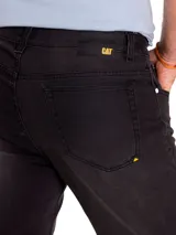 Jeans slim de corte ajustado en color gris oscuro con efecto deslavado, diseño de cinco bolsillos y un leve roto en la rodilla derecha.